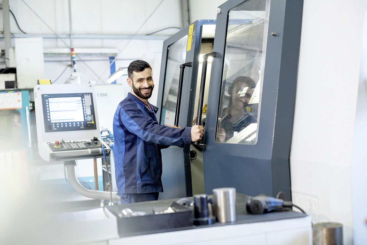 Facharbeiter bedient eine CNC-Drehmaschine zur präzisen Fertigung von Metallbauteilen.